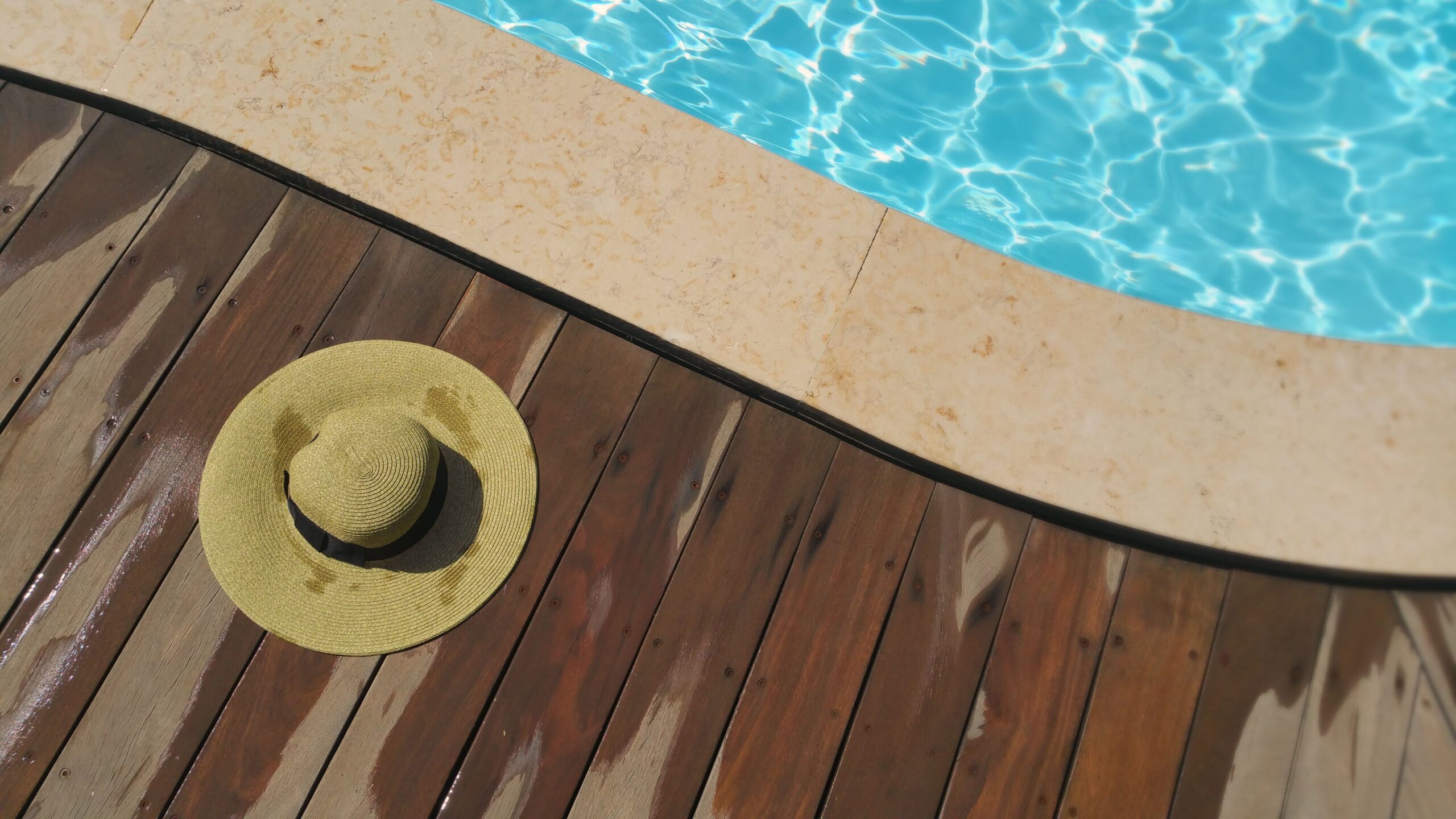 Plage de piscine en bois avec transats, aménagement abords de bassin